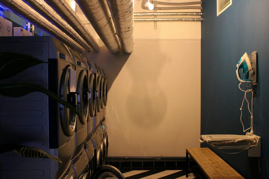 Laundry room with washers, dryers, and overhead ducting